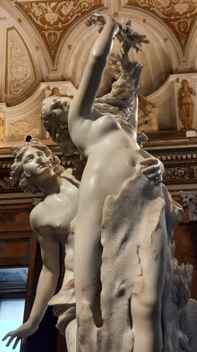 "Apolo e Dafne" è una scultura di Gian Lorenzo Bernini realizzata tra il 1620 e il 1625, quando Bernini aveva circa 22-27 anni. Questa opera, scolpita in marmo di Carrara, rappresenta il momento in cui Apollo insegue Dafne, che si trasforma in un albero di alloro per sfuggirgli. È considerata un capolavoro del barocco per la sua espressività e per il modo in cui Bernini cattura il movimento e la fluidità dei corpi. Galleria Borghese. Fotografia: Laura Megna